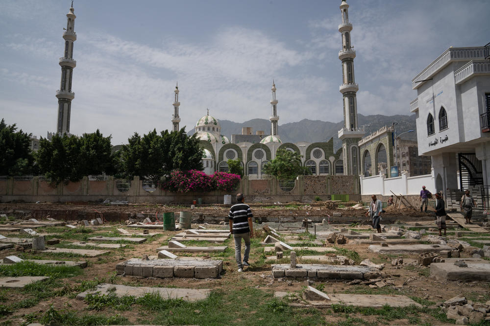 A man walks through a cemetery where there are graves for people who died during the war. The United Nations estimates that the conflict in Yemen caused over 377,000 deaths.