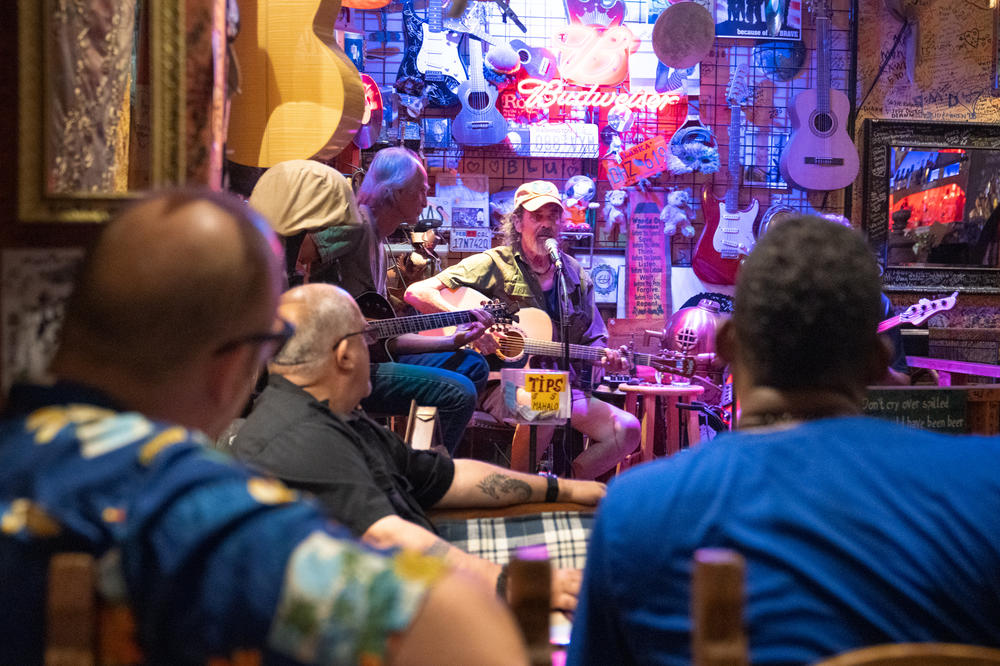Rick Glencross plays music at Java Jazz. He lost his home in the fire in Lahaina and is sleeping in his car with his dog.