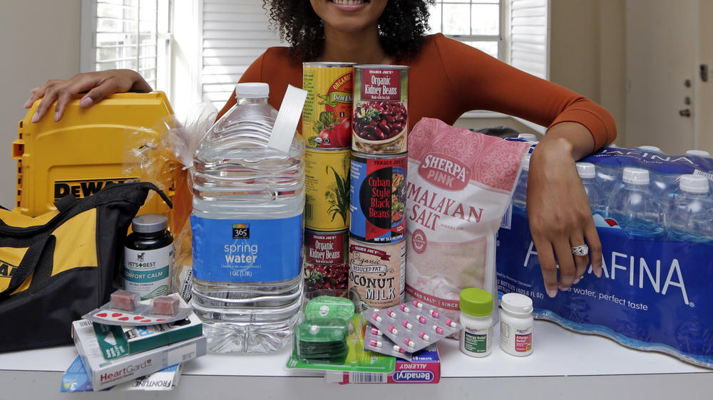 In this Friday, Sept. 29, 2017, photo, Lexi Montgomery poses with supplies she has purchased in the event of another storm, in Miami Beach, Fla. Hurricane Irma was the first hurricane that Montgomery ever experienced.