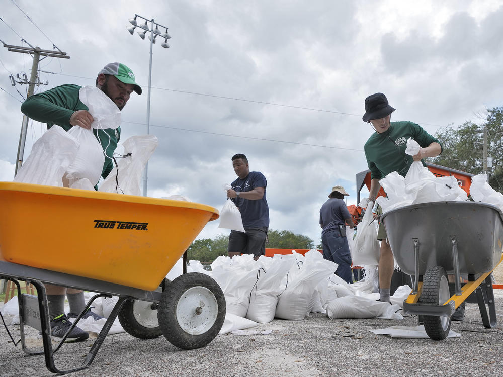 Members of the Tampa, Fla., Parks and Recreation Department help residents with sandbags on Monday, Aug. 28, 2023. Residents along Florida's gulf coast are making preparations for the effects of Tropical Storm Idalia.