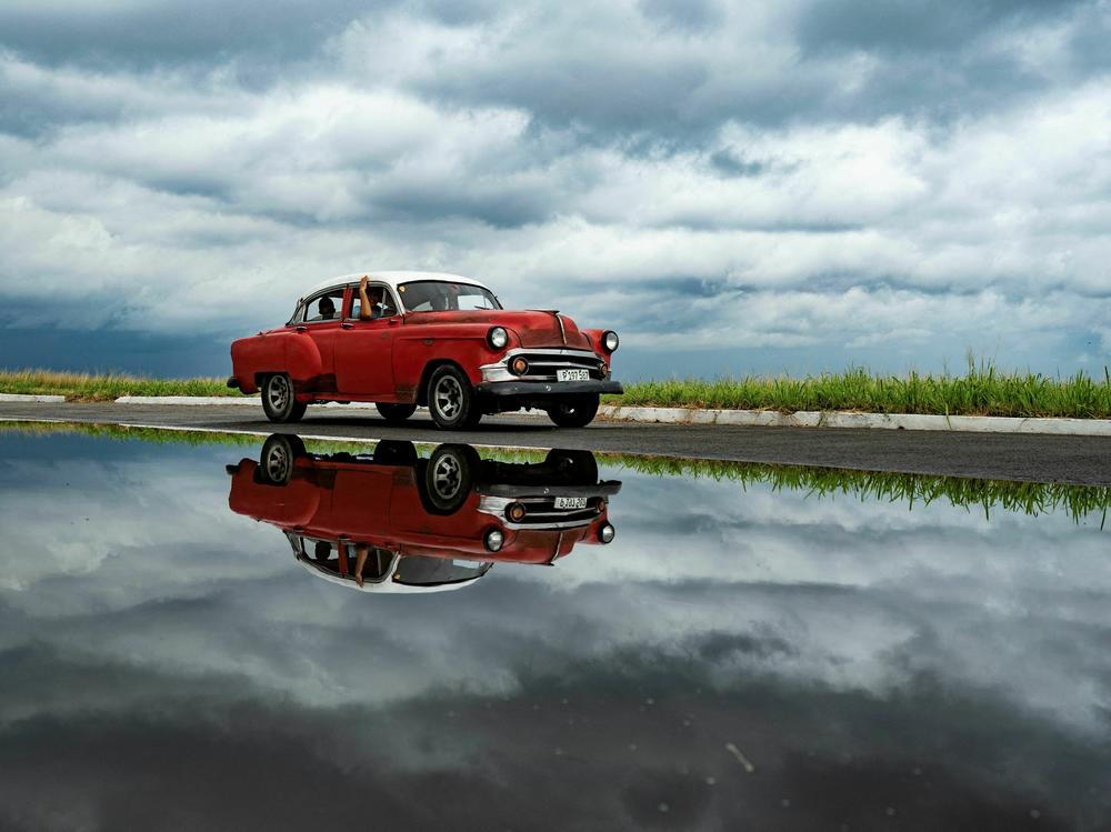 An old car passes by in Havana while dark clouds loom due to Tropical Storm Idalia on Monday.