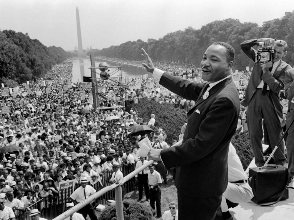 Martin Luther King Jr. waves to the crowd during the 