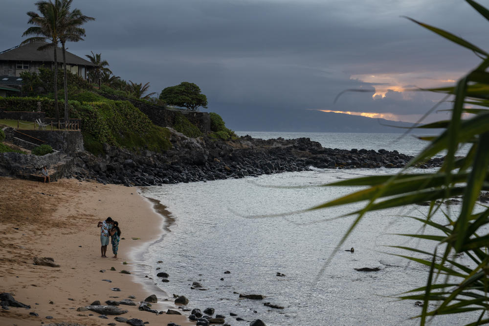 Tourists take a selfie at sunset on an empty beach in Paia on Monday.