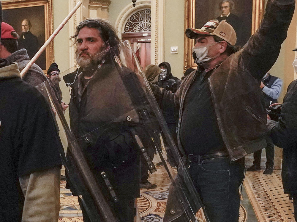 In this Jan. 6, 2021, photo, rioters, including Dominic Pezzola, with a police shield, are confronted by U.S. Capitol Police officers outside the Senate chamber inside the Capitol on Jan. 6, 2021.