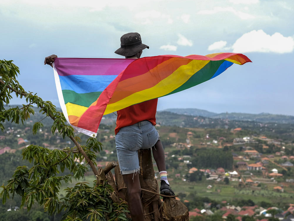 A gay Ugandan man holds a pride flag as he poses for a photograph in Uganda in March.