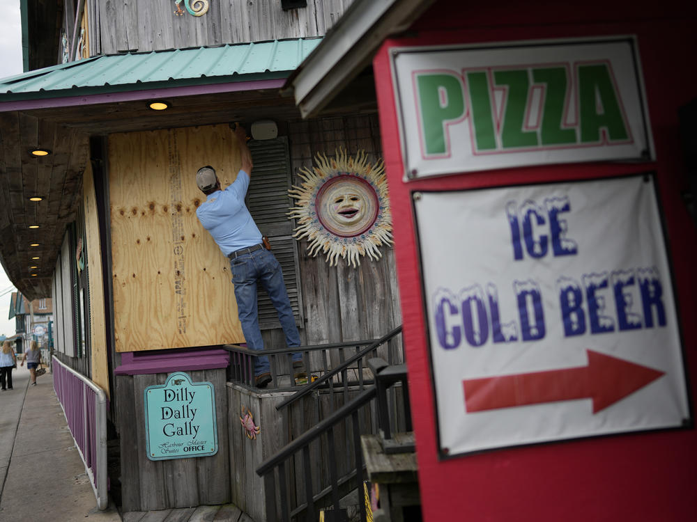 Adam Henderson, owner of Harbour Master Suites, prepares his business Tuesday in Cedar Key, Fla., ahead of the expected arrival of Hurricane Idalia.