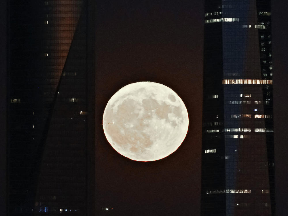 This picture taken on Aug. 1, 2023, shows the second supermoon of 2023, also known as the sturgeon moon, rising behind the Cuatro Torres business area in Madrid.