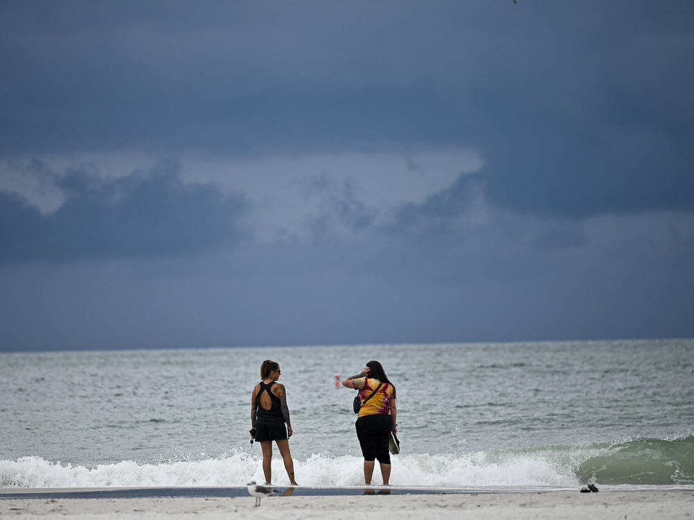 People are shown at the beach in Tampa, Fla., on Tuesday as the city prepares for Hurricane Idalia.