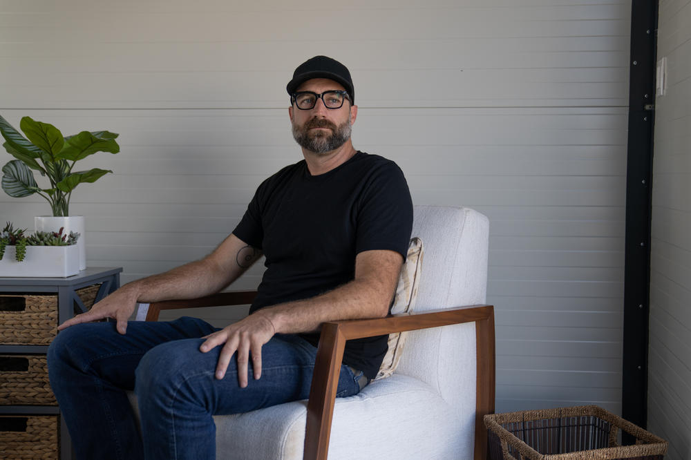 David Sellers, an architect with Hawaii Off-Grid, is helping to set up some temporary housing for people displaced by the Lahaina fires. He's seen here sitting in one of the pop-up units.