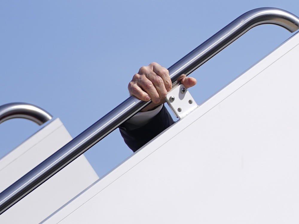 President Biden grips the hand rail of the tall stairs as he stumbles while boarding Air Force One at Andrews Air Force Base, Md., on March 19, 2021.