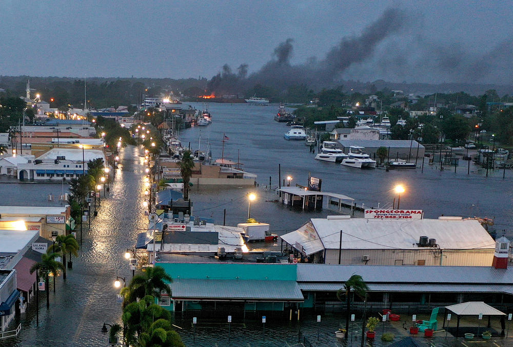 In an aerial view, a fire is seen as flood waters inundate the downtown area after Hurricane Idalia passed offshore on August 30, 2023 in Tarpon Springs, Florida.