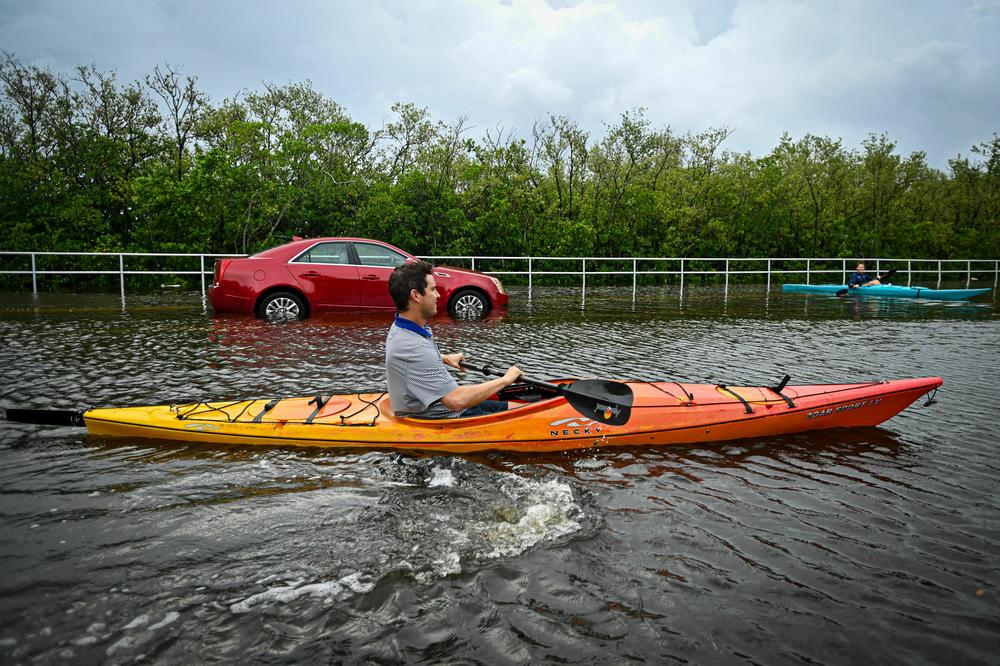 Residents use kayaks to travel on a flooded road in Tampa, Florida,  Hurricane Idalia made landfall.