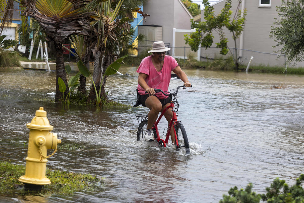 A resident rides a bicycle through floodwaters from Hurricane Idalia in Gulfport, Florida, US, on Wednesday, Aug. 30, 2023.