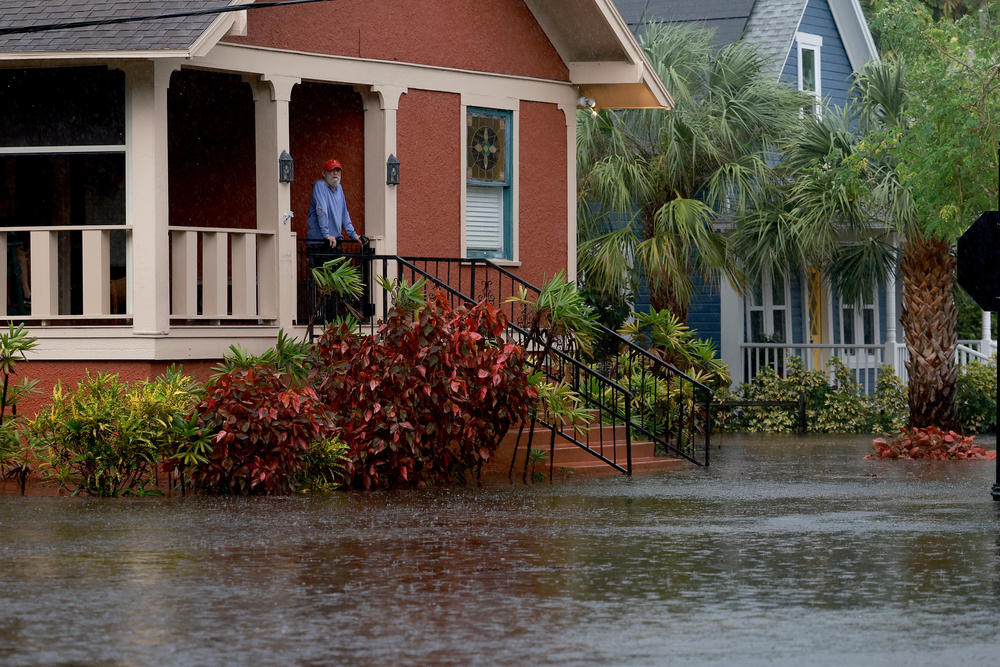 Steve Odom stands on the porch of his home that is surrounded by flood waters caused by Hurricane Idalia passing offshore in Tarpon Springs, Florida.