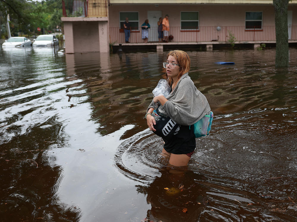 Makatla Ritchter wades through flood waters after having to evacuate her home when the flood waters from Hurricane Idalia inundated it on August 30, 2023 in Tarpon Springs, Florida.