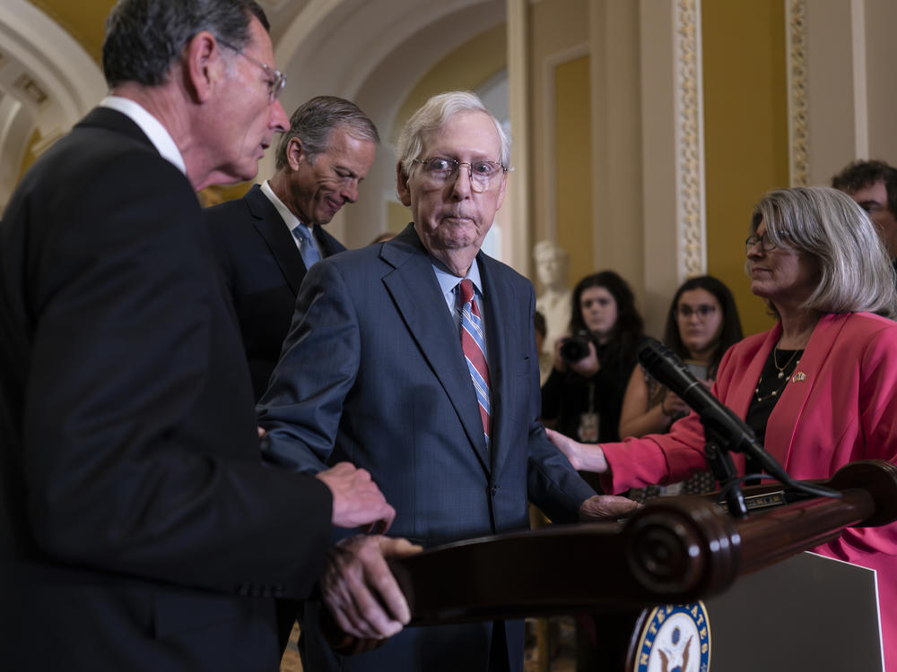 Senate Minority Leader Mitch McConnell, R-Ky., center, is helped by, from left, Sen. John Barrasso, R-Wyo., Sen. John Thune, R-S.D., and Sen. Joni Ernst, R-Iowa, after the 81-year-old GOP leader froze at the microphones as he arrived for a news conference, at the Capitol in Washington on July 26.