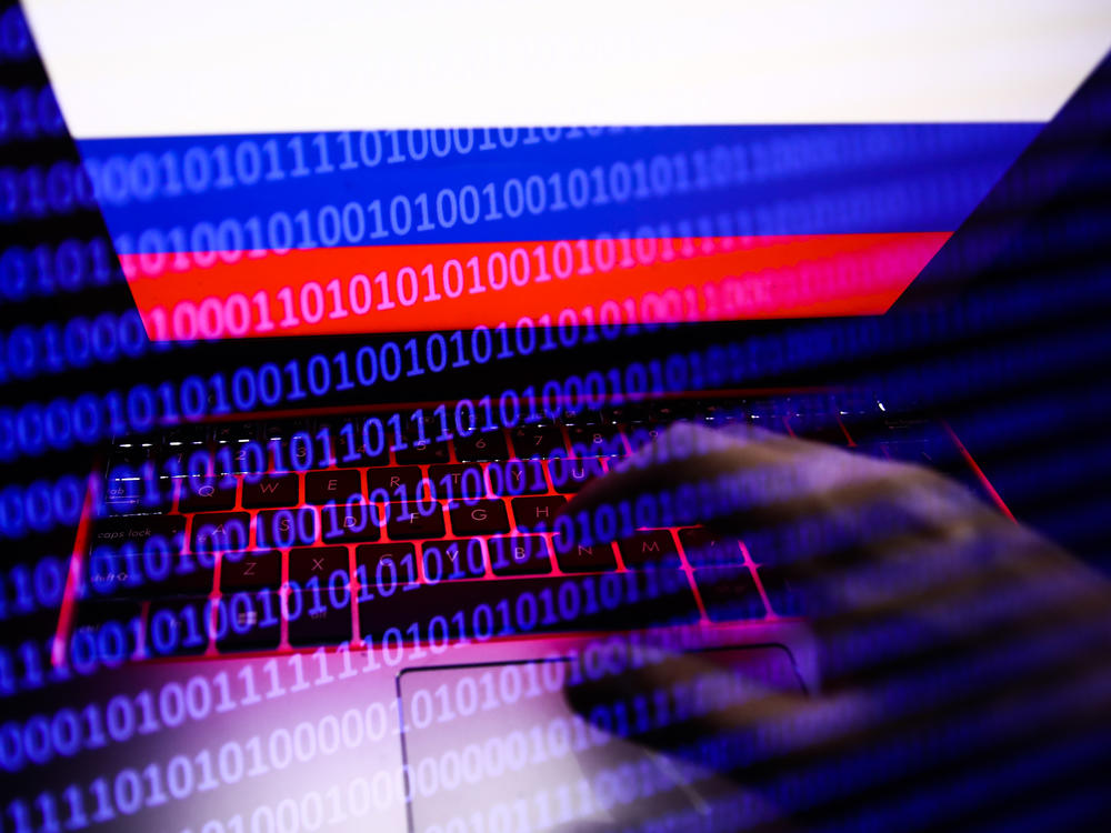 Russian flag displayed on a laptop screen and binary code code displayed on a screen are seen in this multiple exposure illustration photo taken in Krakow, Poland on Feb. 16, 2022.