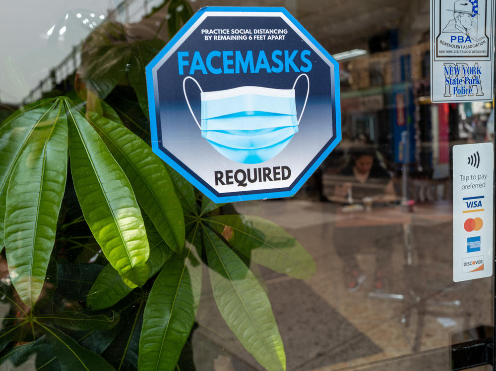 A face mask sign is displayed in a window in Queens, New York City on May 11, the day the federal public health emergency for COVID ended.