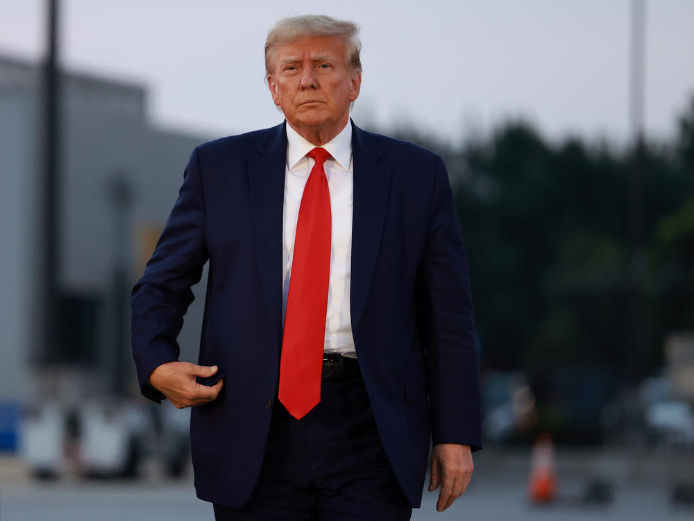 Former President Donald Trump arrives at Atlanta Hartsfield-Jackson International Airport after being booked at the Fulton County jail on Aug. 24.