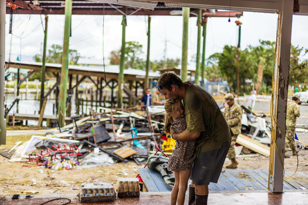 John Neal hugs his daughter Erin Rose at his damaged property.