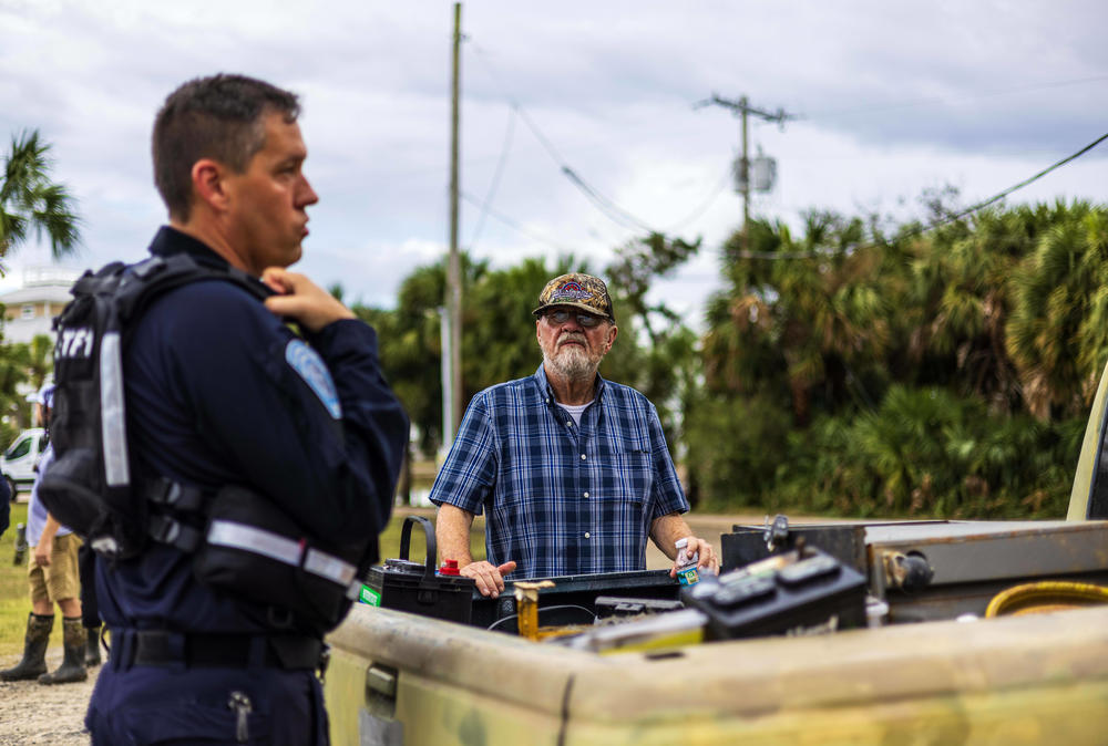 Dennis Buckley, right, surveys his property after the hurricane.