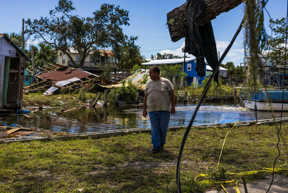 Austin Ellison stares at his damaged property after Hurricane Idalia on Thursday in Horseshoe Beach, Fla. Ellison's family owns a seafood and shrimping business.