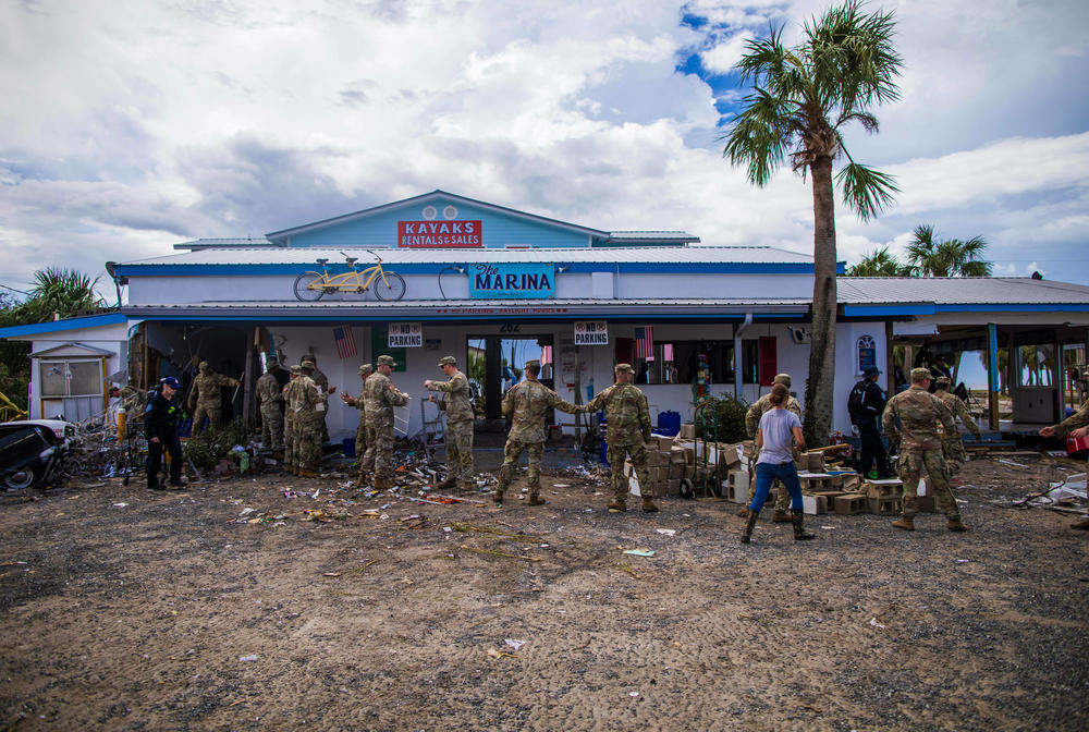 The army reserve helps clean up a damaged property.