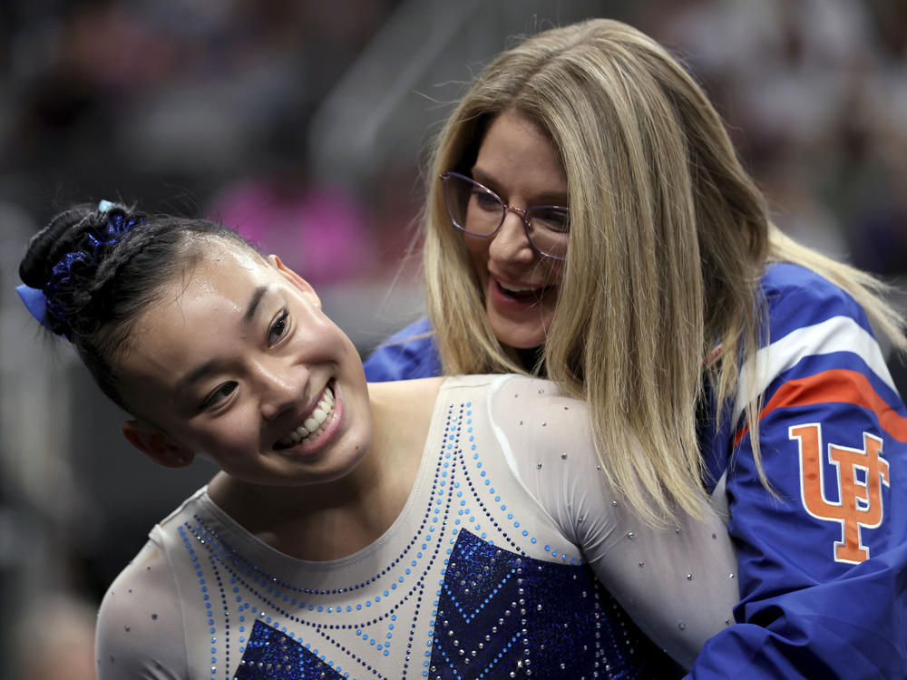 Leanne Wong, left, is congratulated by her coach Jenny Rowland after competing in the floor exercise at the championships. Wong competes at the University of Florida, where Rowland is her coach.