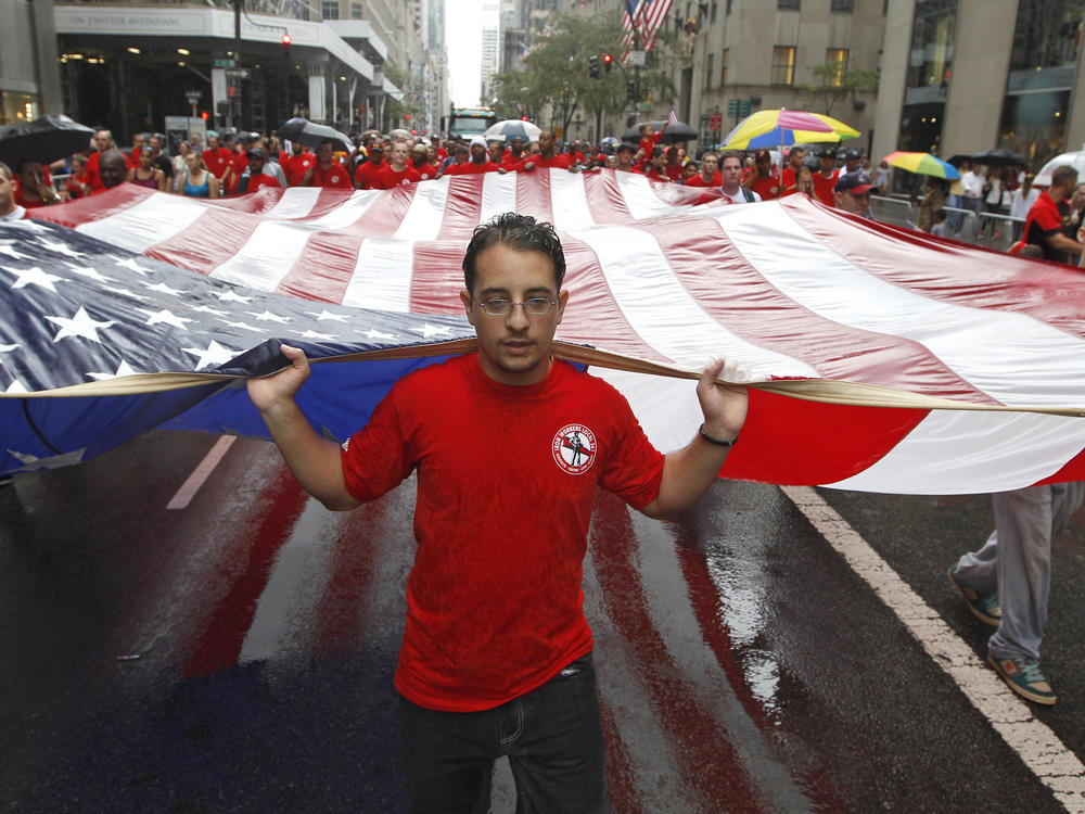 Local 361 iron worker Robert Farula marches up Fifth Avenue carrying an American flag during the Labor Day parade on Sept. 8, 2012, in New York.