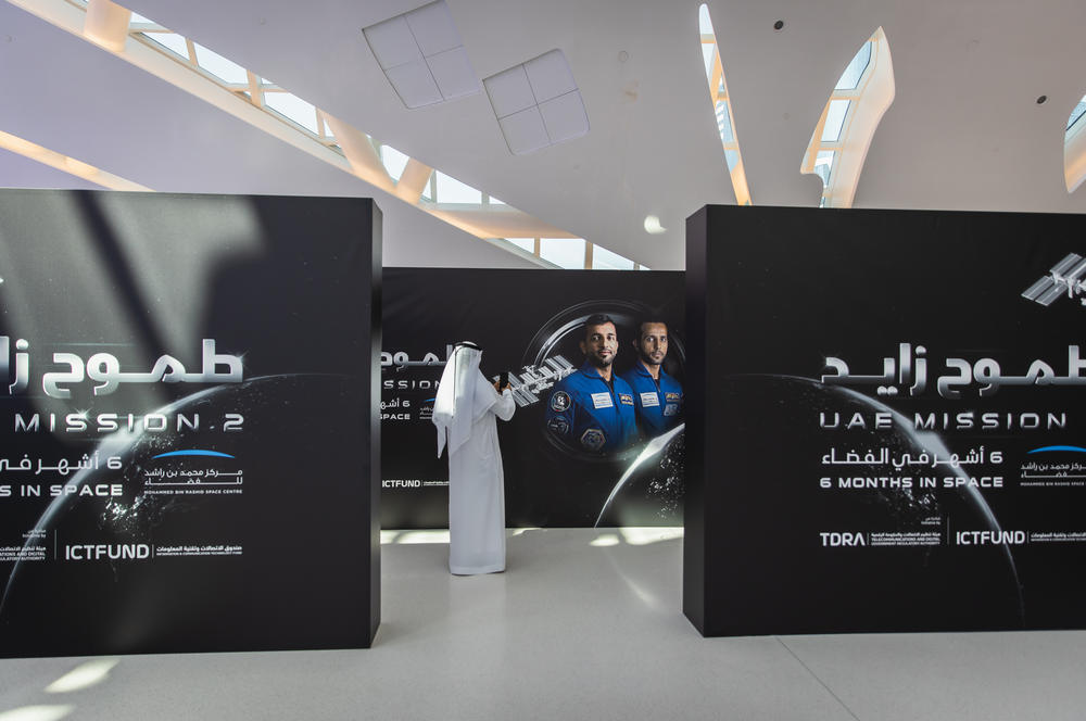 An attendee takes a photo of UAE astronauts Sultan Alneyadi (left) and Hazza Al Mansouri during a press conference held by the Mohammed Bin Rashid Space Centre on Feb. 2, in Dubai, United Arab Emirates.