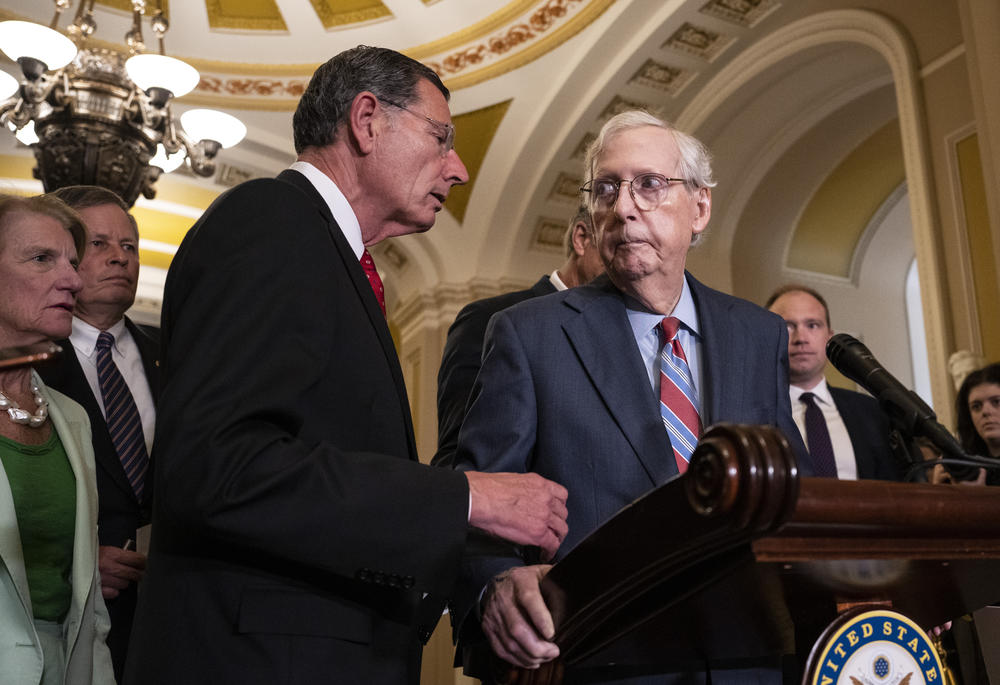 Sen. John Barrasso, R- Wy., reaches out to help Senate Minority Leader Mitch McConnell, R-Ky., after McConnell froze and stopped talking at the microphones during a news conference after a lunch meeting with Senate Republicans U.S. Capitol in late July.  Also pictured, L-R, Sen. Shelley Moore Capito, R- W.Va., Sen. Steve Daines, R-Mont.
