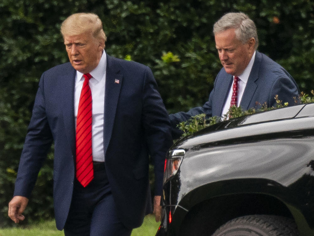 Then-President Donald Trump talks to White House chief of staff Mark Meadows, right, as they walk from the Oval Office at the White House on Sept. 12, 2020.