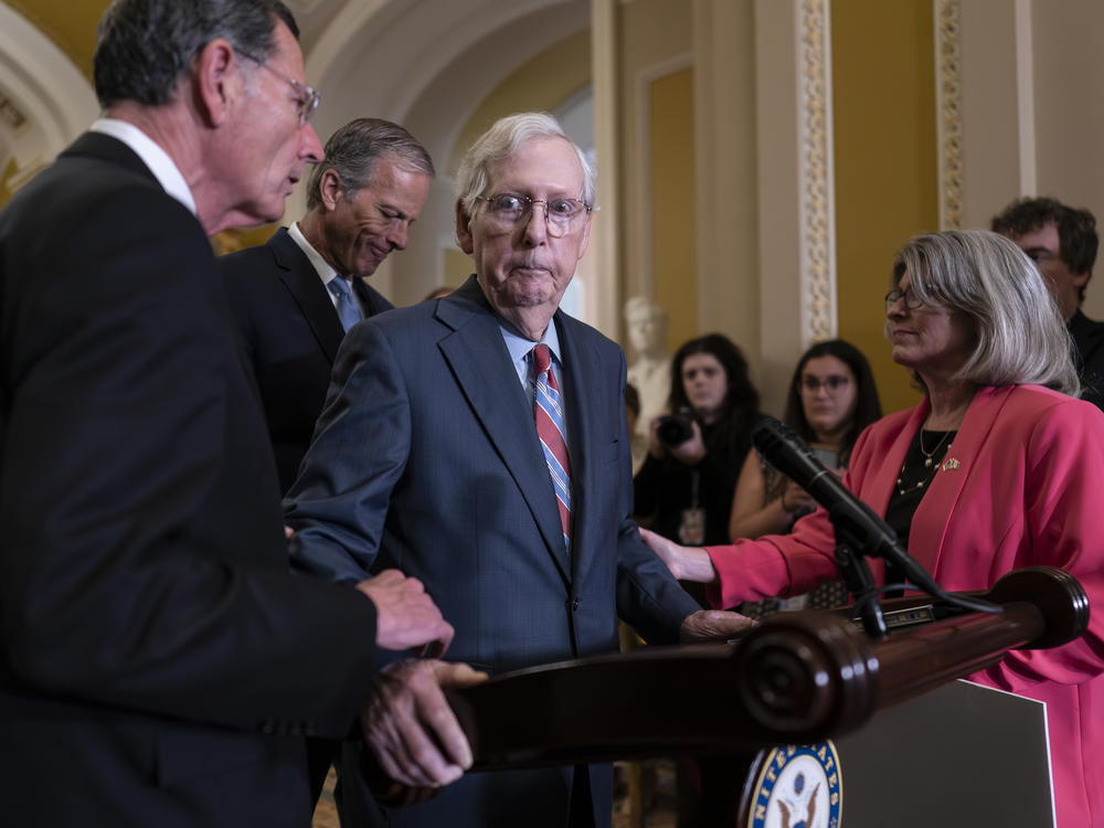 Senate Minority Leader Mitch McConnell, R-Ky., center, is helped by, from left, Sen. John Barrasso, R-Wyo., Sen. John Thune, R-S.D., and Sen. Joni Ernst, R-Iowa, after the 81-year-old GOP leader froze at the microphones on  July 26.
