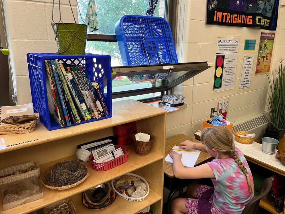 An elementary student at Maryland Avenue Montessori in Milwaukee sits under an open window and fan. Milwaukee Public Schools dismissed students early Tuesday due to hot temperatures and lack of air conditioning in most schools.