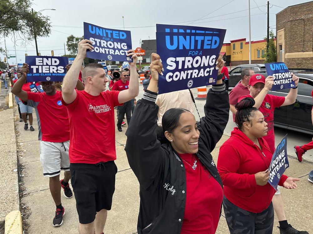 United Auto Workers members march while holding signs at a union rally held near a Stellantis factory Wednesday, Aug. 23, 2023, in Detroit.