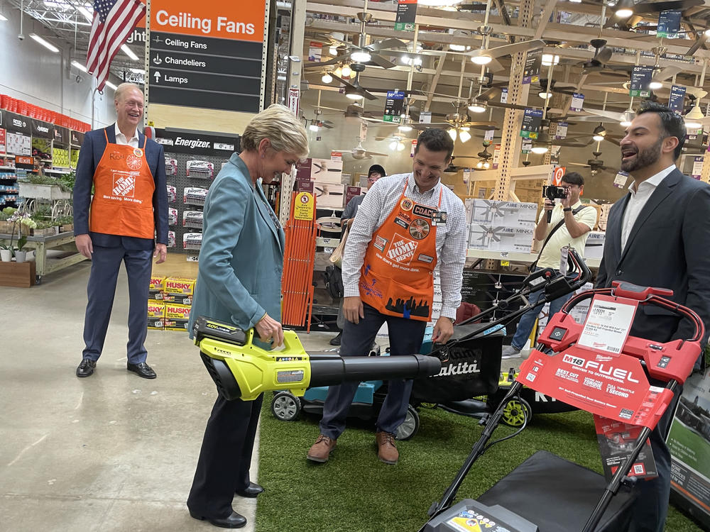 Energy Secretary Jennifer Granholm tests out an electric leaf blower at a Home Depot stop near Atlanta. In addition to promoting electric vehicles, the federal government has funded new rebates for low-income households that buy cleaner appliances or other upgrades. States are still working on the details for administering those programs.