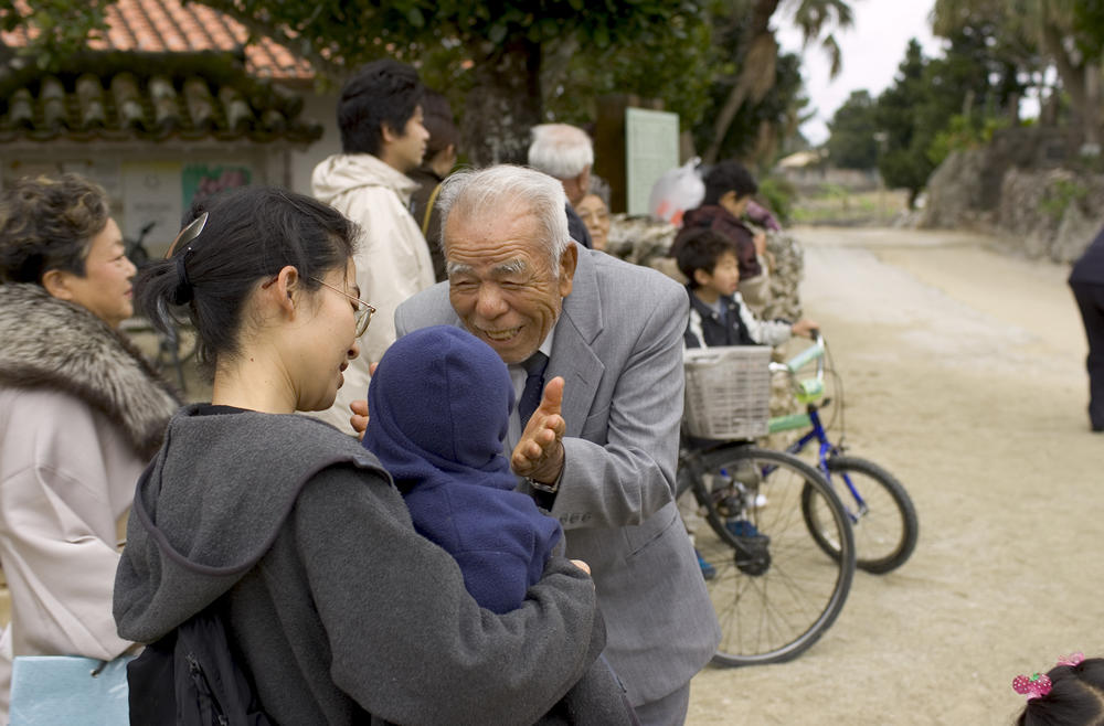 At a family gathering on the Okinawan island of Taketomi, a 90-year-old islander greets a young relative.