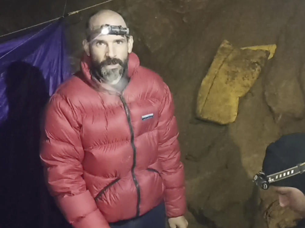 In this screen grab from video, American caver Mark Dickey, 40, talks to camera next to a colleague inside the Morca cave near Anamur, southern Turkey, Thursday, Sept. 7, 2023. Turkish and international cave rescue experts are working to save an American speleologist trapped at a depth of more than 1,000 meters (3,280 feet) in a cave in southern Turkey after he became ill.