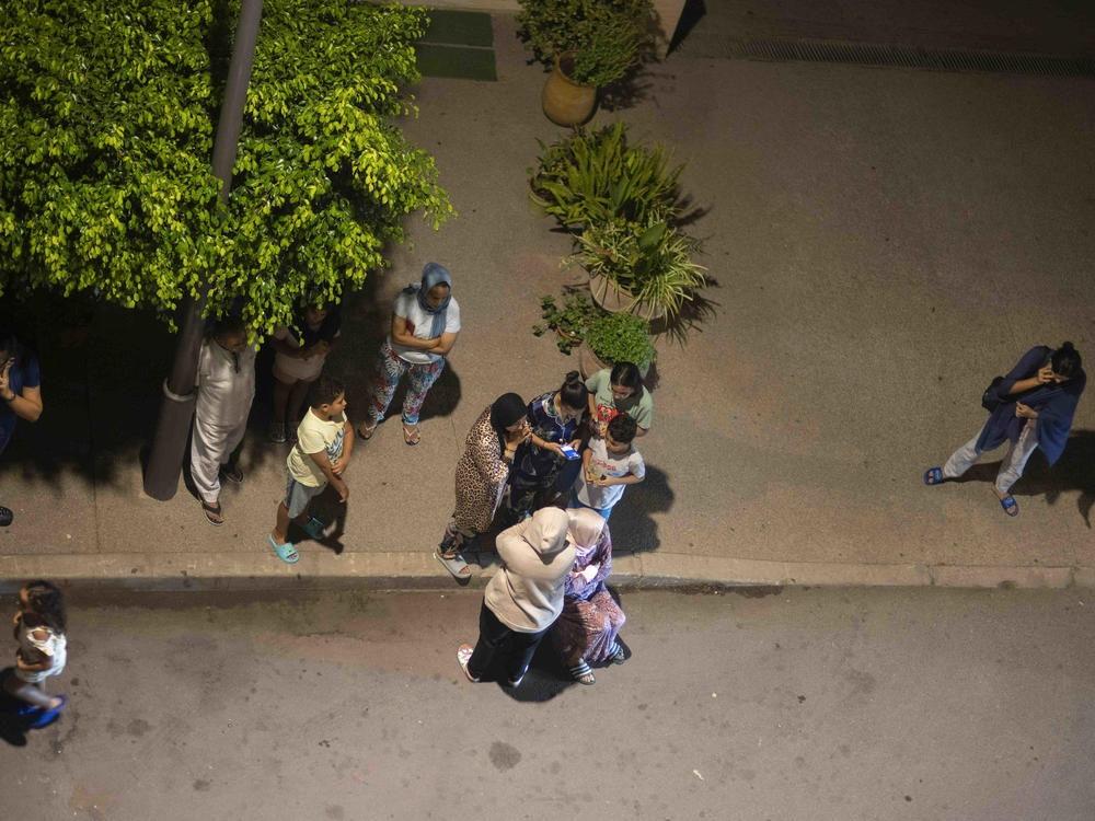 People take shelter and check for news on their mobile phones after an earthquake in Rabat, Morocco, late Friday, Sept. 8, 2023.
