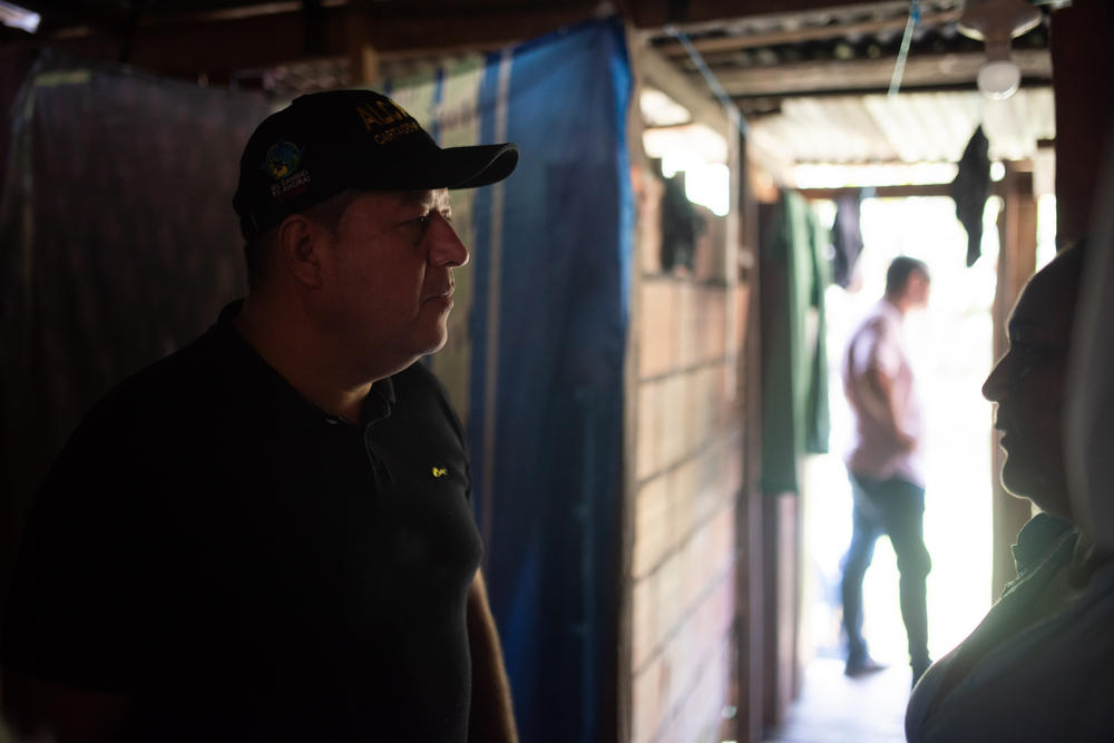 The mayor inside the home of a resident who wants him to pave the street that runs past her house.