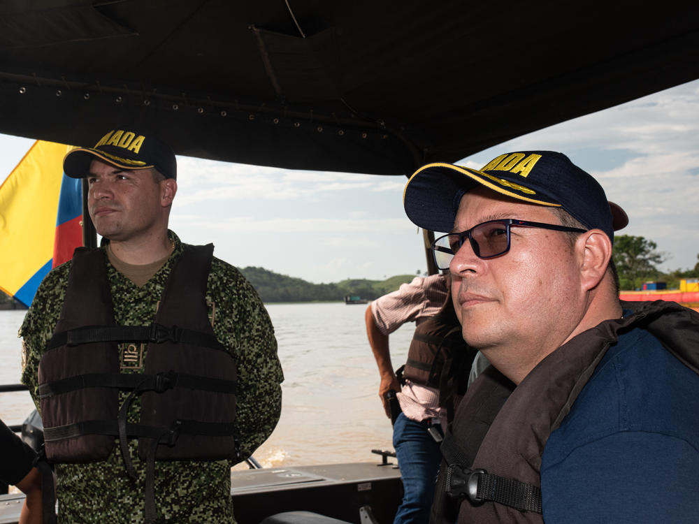 Mayor Edilberto Molina (right), alongside Lt. Col. Óscar Usme aboard a well-armed Colombian Navy boat, tour the Caguán River which flows past Cartagena del Chairá.