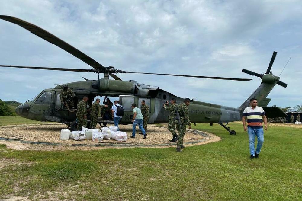 To avoid being ambushed by rebels on the road out of town, Molina — who is wearing a black backpack and climbing aboard the chopper — flies in and out of Cartagena del Chairá on army helicopters.