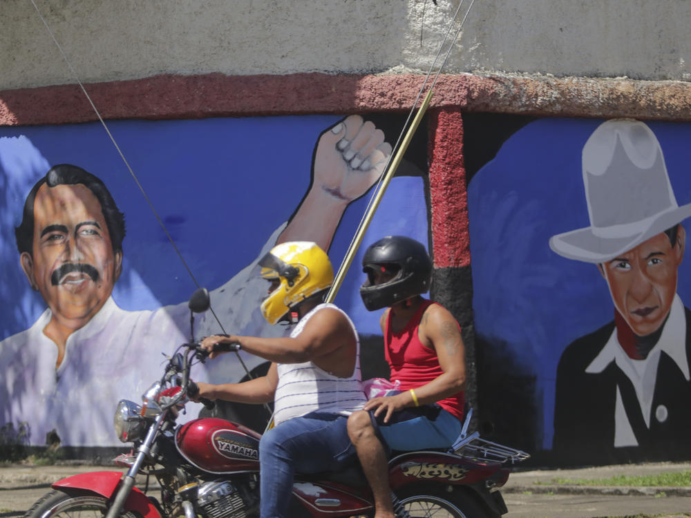 A motorcyclist rides past a mural of Nicaraguan President Daniel Ortega, left, and revolutionary hero CÃ©sar Augusto Sandino<em> </em>during general elections in Managua, Nov. 7, 2021. Ortega won a fourth consecutive term against a field of little-known candidates while those who could have given him a real challenge sat in jail.