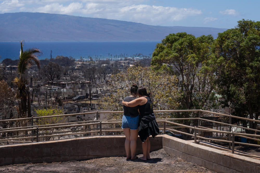 Two women embrace and cry as they look out over a burned area of Lahaina on Aug. 22.