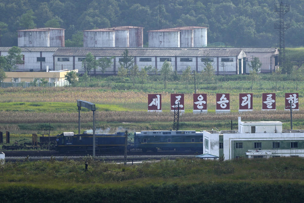 On Monday, a green train with yellow trimmings, resembling one used by Kim Jong Un on his previous travels, is seen steaming by a slogan which reads 