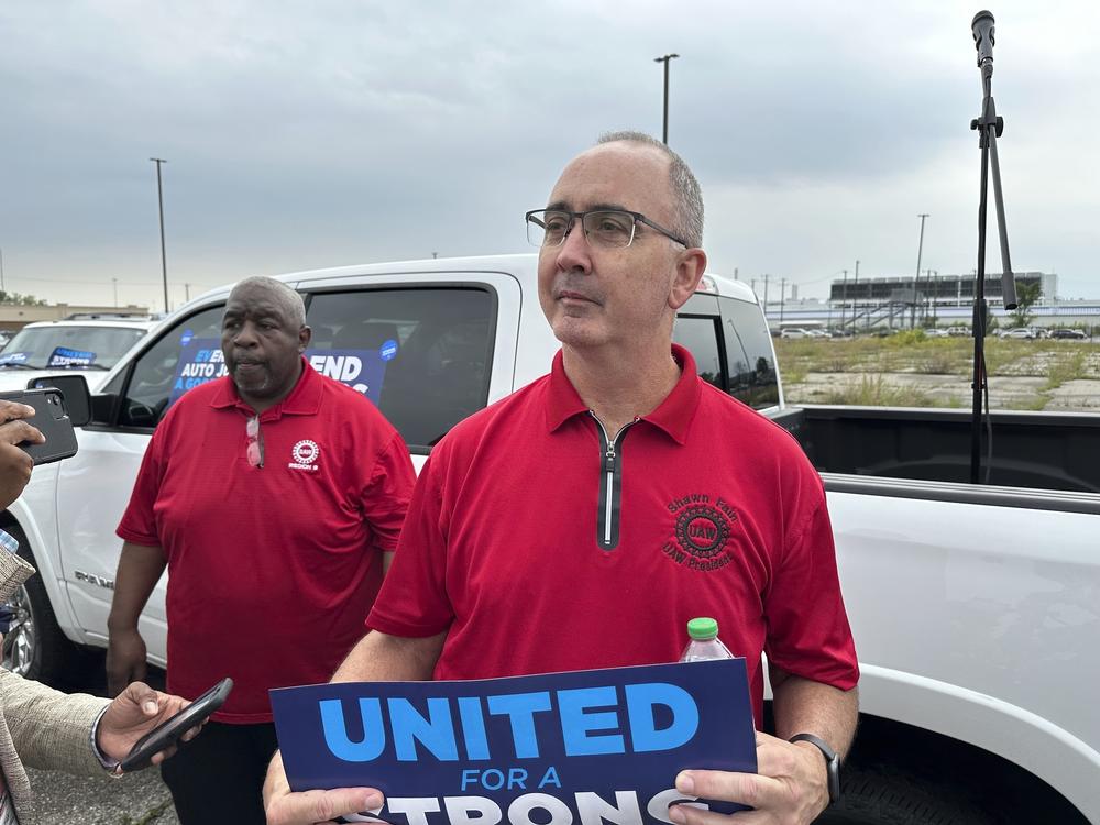 United Auto Workers President Shawn Fain holds a sign at a union rally held near a Stellantis factory in Detroit on Aug. 23.