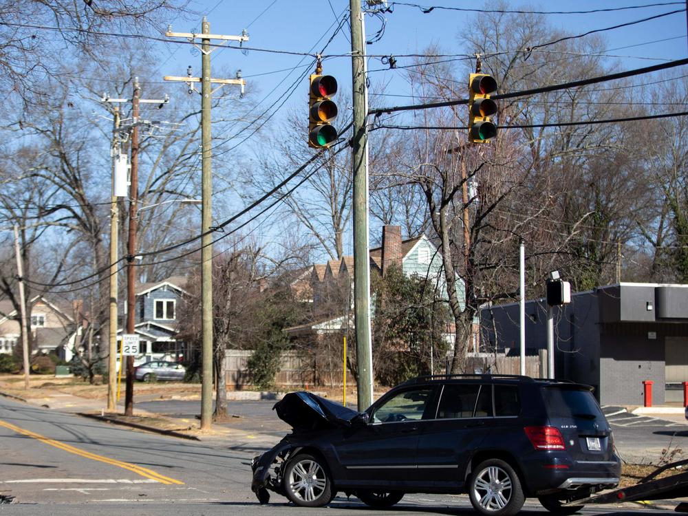 A car accident is cleared at an intersection without power in Charlotte, N.C., on Dec. 24, 2022. Auto insurance costs are soaring — well outpacing overall inflation.