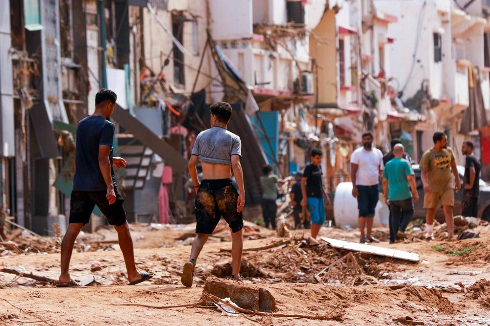 People check an area damaged by flash floods in Derna, eastern Libya, on Monday.