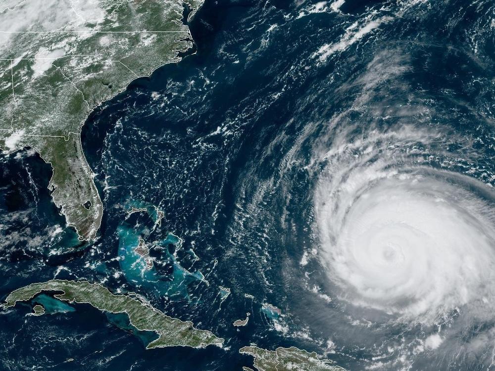 A satellite image shows Hurricane Lee spinning over open water between Puerto Rico and Bermuda.