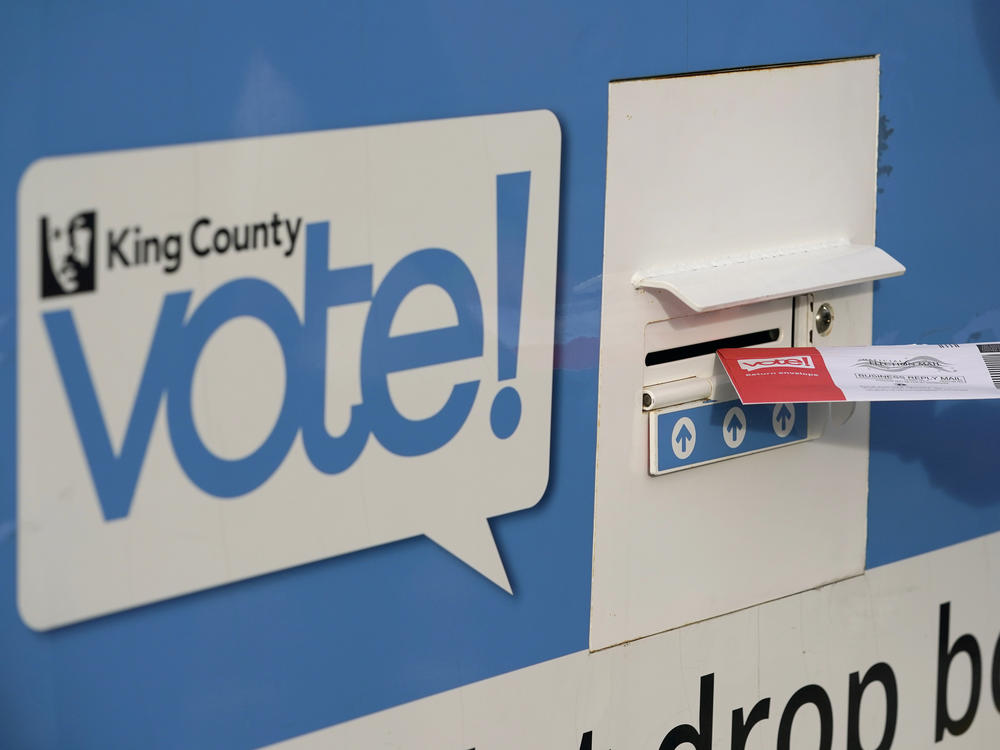 A person puts their ballot in a drop box on Oct. 27, 2020, at a library in Seattle. Under Washington state's primary system, the top two vote getters advance to the general election in November, regardless of party.